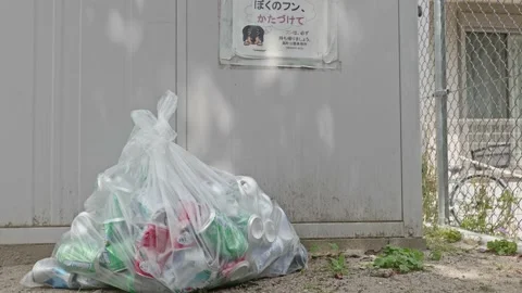 A garbage bag containing an empty can left in a park Stock Footage 133862091