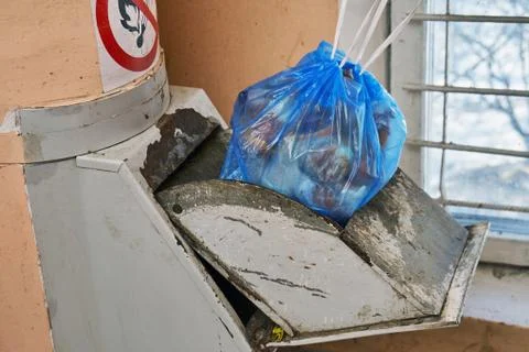 Garbage bag full of a garbage lying in a lid of a home garbage chute Фото