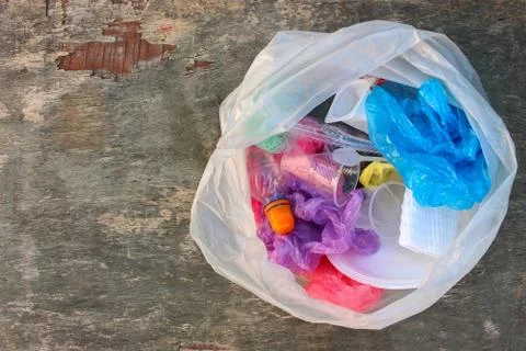 Garbage bag with plastic trash on old wooden background. Top view. Concept ga Stock Photos