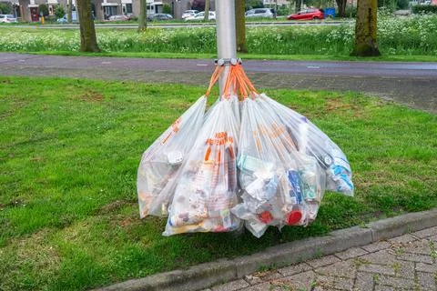 Garbage bags hanging from a lamppost Stock Photos