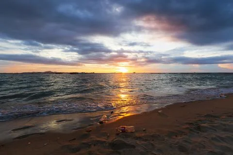 Garbage on the beach in sunset light Stock Photos