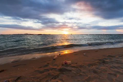 Garbage on the beach in sunset light Foto stock