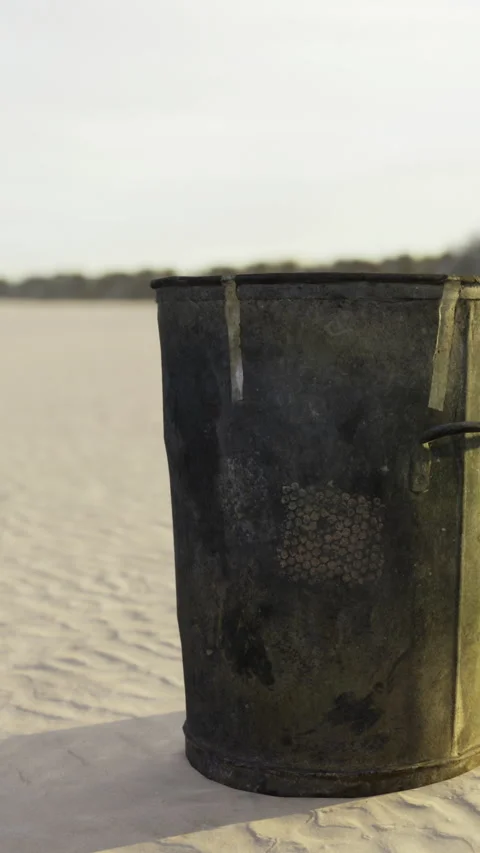Garbage bin placed on sandy beach during day Stock Footage 334882215