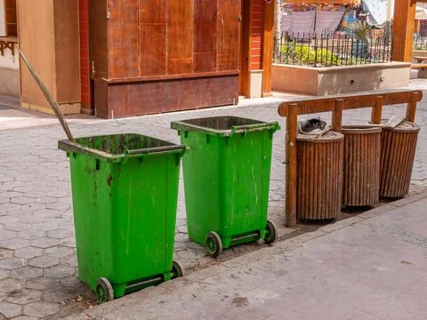 Garbage bins and garbage collection containers on city streets. Stock Photos