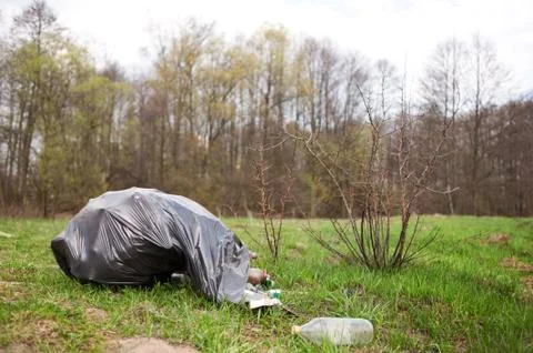 Garbage in black plastic bag dump in woods Stock Photos
