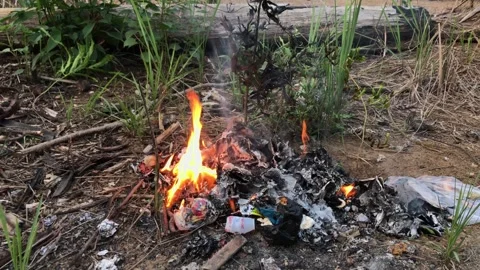 Garbage burn on the ground. waste burning . 4k video Stock Footage 254528636