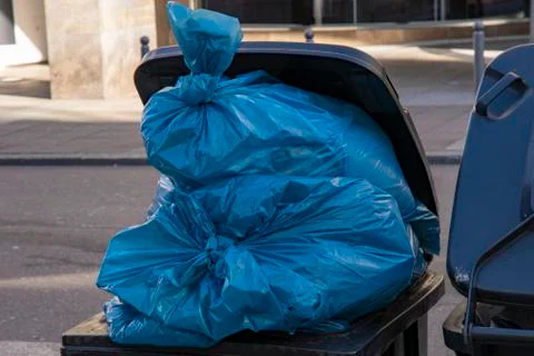 Garbage can full of blue garbage bags Stock Photos