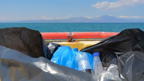 Garbage can full of garbage with sea, ocean on background. logged sea Stock Footage 116716869