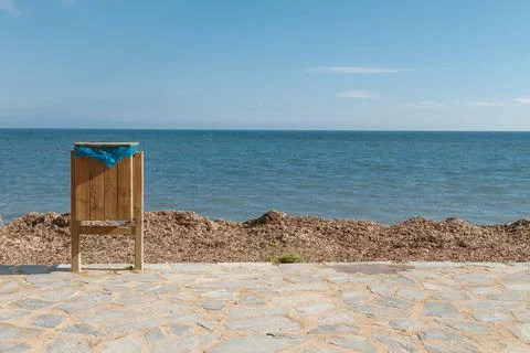 Garbage can standing on the seashore on the background of a beautiful sky and Stock Photos