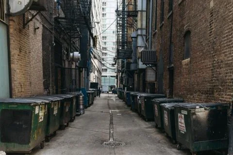 Garbage cans stand between buildings in a courtyard of Chicago. Stock Photos