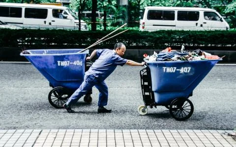 Garbage in China. Scavenger pulls two trash cans Stock Photos