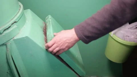 The garbage chute in the house. A man throws waste in a green bucket Stock Footage 230985578