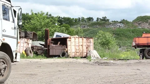 A garbage collector is driving through a city dump. Stock Footage 77363230