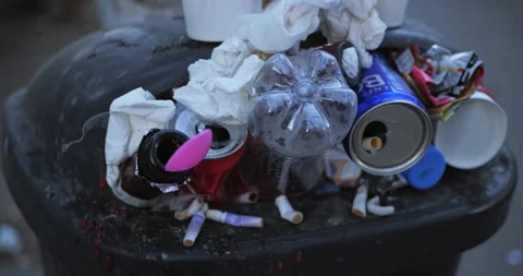 Garbage container filled to top with various empty trash, plastic cups, empty Stock Footage 236861615