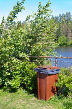 Garbage container by river Stock Photos