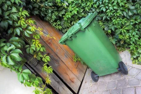 Garbage container in the yard by the barn door Stock Photos