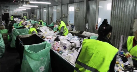 Garbage containers in the room. Heaps of plastic, cellophane. People sort the Stock Footage 156078463