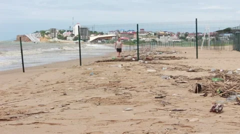 Garbage, dirty beach, ocean, dirty sea and lonely man walking on the dirty beach Video stock 51770548