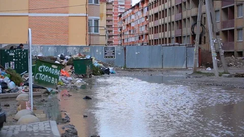 Garbage dump and huge dirty puddle through which person tries to pass Video stock 101540353