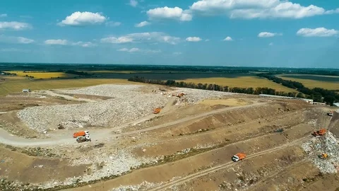 Garbage dump on the background of green fields. Garbage disposal equipment goes Vídeos de archivo 114495229