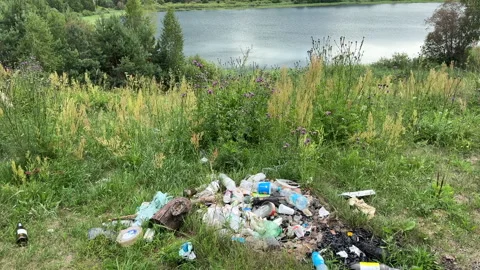 Garbage dump in Illegal location. People throw garbage near lake Stock Footage 252102775