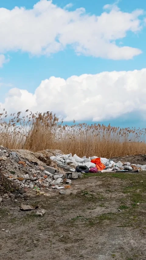 Garbage dump near the river. Ecological Problem. Illegal construction waste dump Stock Footage 320776160