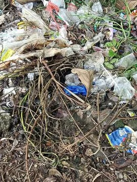 Garbage dumped on the side of a small road. Stock Photos