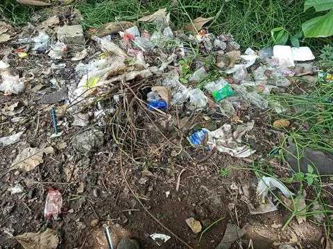 Garbage dumped on the side of a small road. Stock Photos