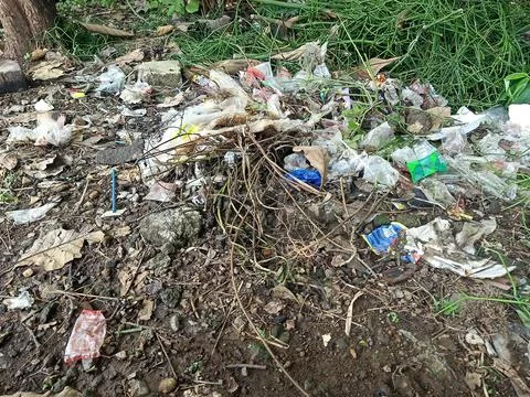 Garbage dumped on the side of a small road. Stock Photos