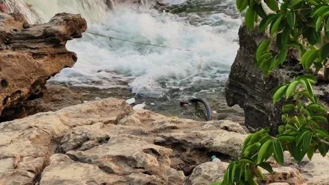 Garbage Floating in River Water Near Rocks Stock Footage 334139289