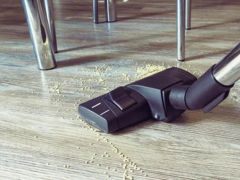 Garbage on the floor is cleaned with a vacuum cleaner. In the frame, a brush  Stock Photos