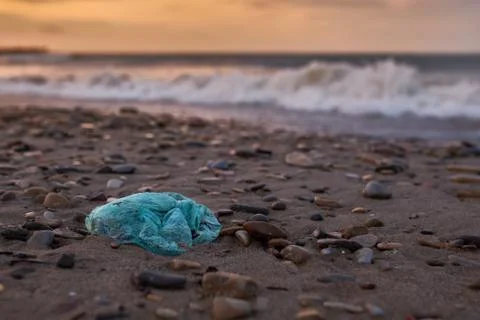 Garbage in the form of a plastic bag lying on the beach Stock Photos