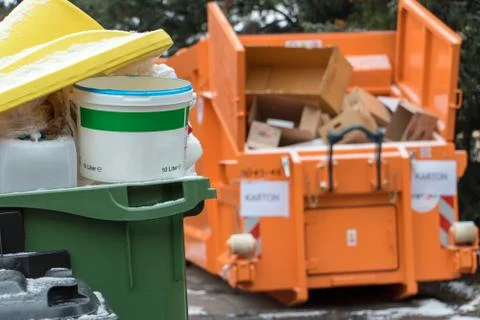 Garbage in full dustbins and a container with separate waste cardboard Foto stock