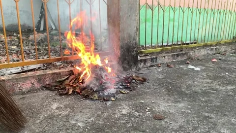Garbage leaves that have fallen on the streets are burned in the afternoon Stock-Footage 241258169
