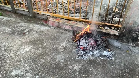 Garbage leaves that have fallen on the streets are burned in the afternoon Stock-Footage 241258214