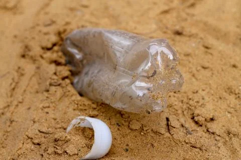 Garbage left on a beach.Plastic bottle left on a beach. Stock Photos