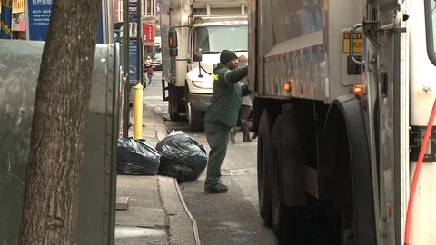 Garbage man picking up trash in New York Stock Footage 104879426