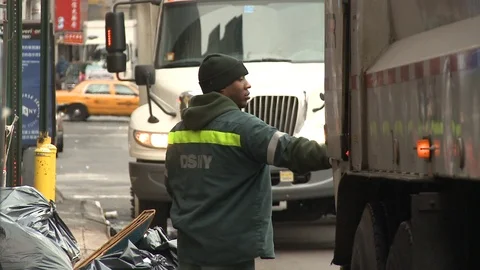 Garbage man picking up trash in New York Stock Footage 104879756