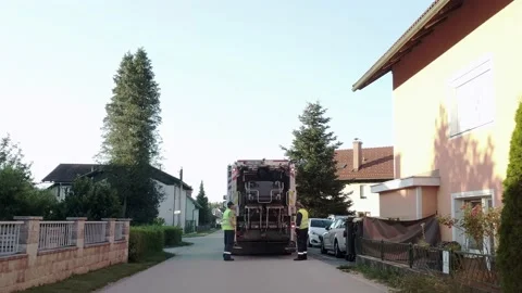 Garbage men collecting trash bins and loading them into the garbage truck. Vidéo 134879993