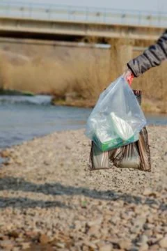 Garbage in the nature, cleaning the environment in the spring on the river fr Stock Photos