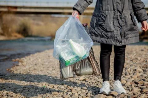 Garbage in the nature, cleaning the environment in the spring on the river fr Stock Photos