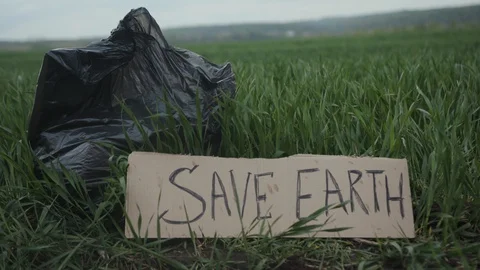 Garbage in a plastic bag plastic bottles lie on the grass on the nature poster Stock Footage 111824876