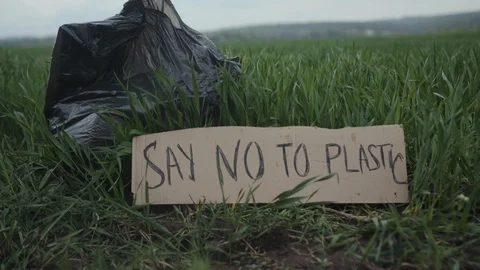 Garbage in a plastic bag plastic bottles lie on the grass on the nature poster Stock Footage 111824940