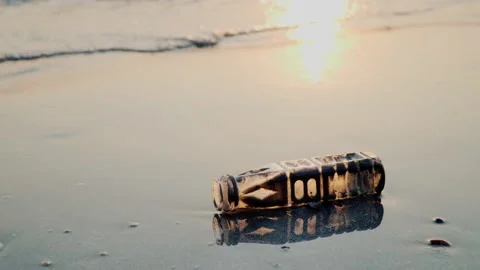 Garbage from plastic bottles washed by the waves on the beach at sunset. Stock Footage 149177108