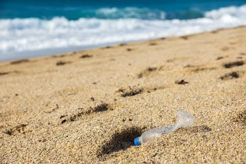 Garbage pollution of the planet. Empty plastic bottle on the beach sand Foto stock