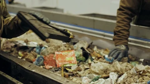 Garbage recycling factory, man worker sorts trash on conveyor belt at waste Stock Footage 231035844