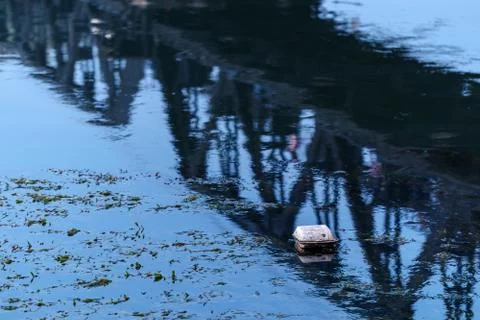 Garbage in river with railway bridge reflection Stock Photos