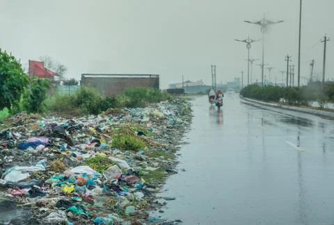 Garbage on roadside in developing country on a rainy day Stock Photos