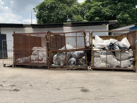 Garbage sack recycling system in a large iron basket Stock Photos