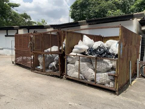 Garbage sack recycling system in a large iron basket Stock Photos